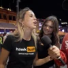 Női modell Hawk Tuah Spit on That Thang pólóban interjú közben