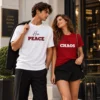 Elegáns fiatal pár Her Peace és His Chaos feliratú páros pólóban, fehér és piros színben.