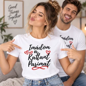 Fiatal nő fehér Imádom a kattant pasimat feliratú páros pólóban, piros szívekkel, mögötte mosolygó párja.
