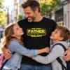 A galaxis legjobb apukája póló fekete színben, The Best Father in the Galaxy sárga felirattal, utcán két gyermekét átölelő édesapán.