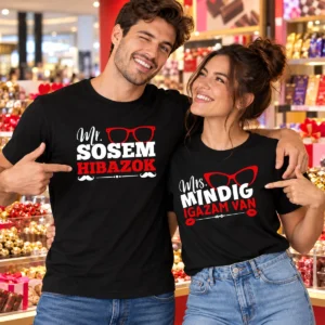 Fiatal pár fekete Mr. sosem hibázok és Mrs. mindig igazam van feliratú pólókban, csokoládéüzletben.