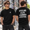 Fekete fesztivál streetwear póló modellen, elöl kis fehér hashtag jellel a bal mellkason, hátul nagy #FEELING #LIFE #SUMMER #FESTIVAL feliratokkal.