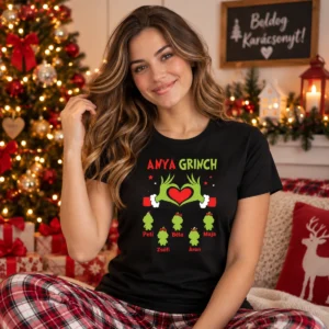 Fiatal nő fekete Anya Grinch karácsonyi pólóban, zöld Grinch-kezekkel, piros szívvel és családi figurákkal
