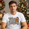 Fiatal férfi fehér Csak a gyász meg a szenvedés Mézi Pólóban, szomorú mézeskalács figurával és karácsonyi grafikával.