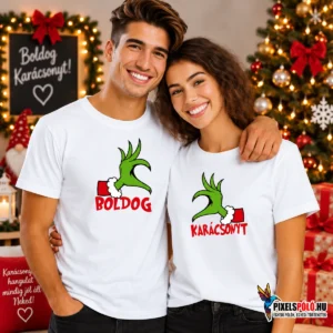 Fiatal pár fehér Grinch Hands Pólóban, összeillő zöld karácsonyi kézgrafikával és Boldog Karácsonyt felirattal.