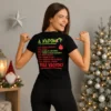 Fiatal nő fekete Grinch napja Pólóban, hátoldalán zöld-piros karácsonyi napirend grafikával és „Tele vagyok!” felirattal.