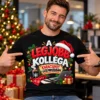 Férfi modell fekete „A legjobb kolléga – karácsonyi üzemmódban” pólóban, ünnepi irodai karácsonyi környezetben.